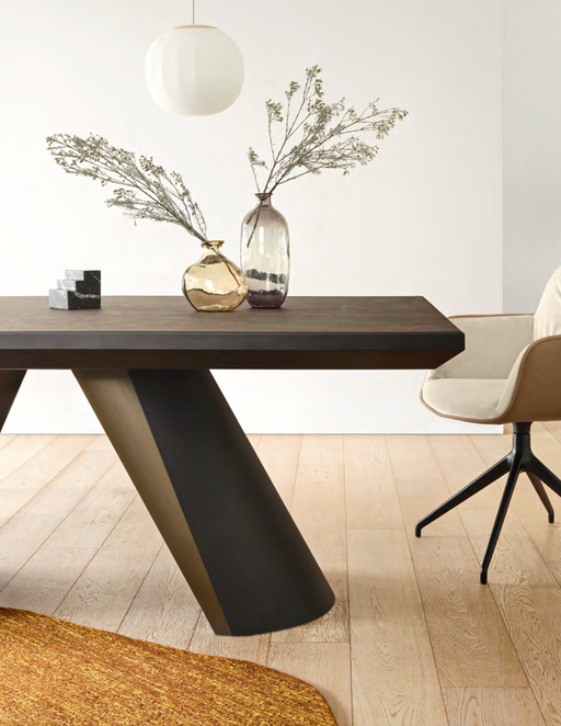A modern dining room with minimalist decor featuring neutral-toned furniture, including a beige chair, dark wood table, and decorative glass vases with dried branches, highlighting trending furniture colors for 2025.
