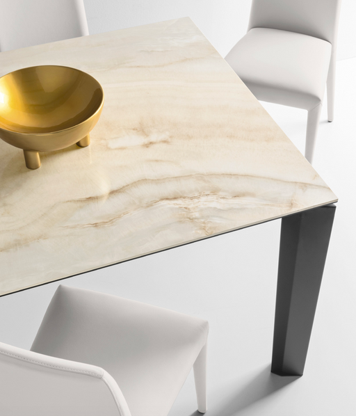 Elegant Italian-designed Calligaris dining table with a polished marble top and modern black legs, complemented by white upholstered chairs.