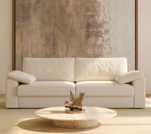 Elegant beige sofa with adjustable armrests in a modern living room featuring a textured wall and marble coffee table, showcasing contemporary furniture design.