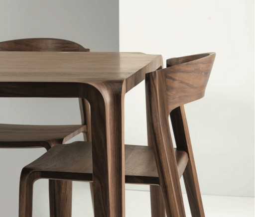 Close-up of elegant solid wood dining table and chairs with smooth, polished surfaces, showcasing high-quality craftsmanship for maintaining solid wood furniture.