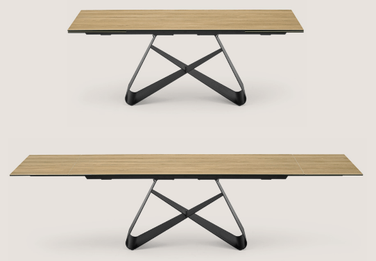 Extending rectangular dining table with a light wood finish, black metal base with geometric design, ideal for space-saving dining areas