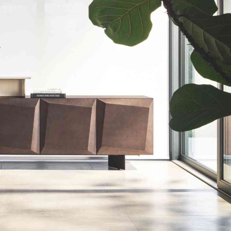 Modern interior with a wooden sideboard, chairs, and decorative items in a bright room.