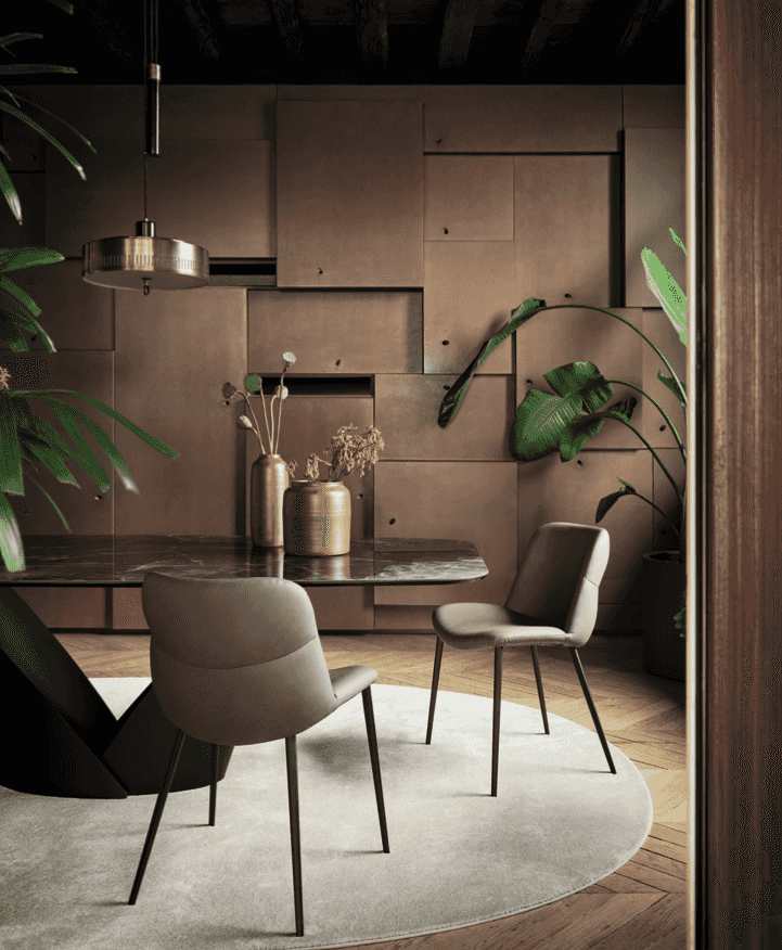 Pair of CS2239 Onda Dining Chairs by Calligaris in a warm-toned dining area with modern decor and lush indoor plants.
