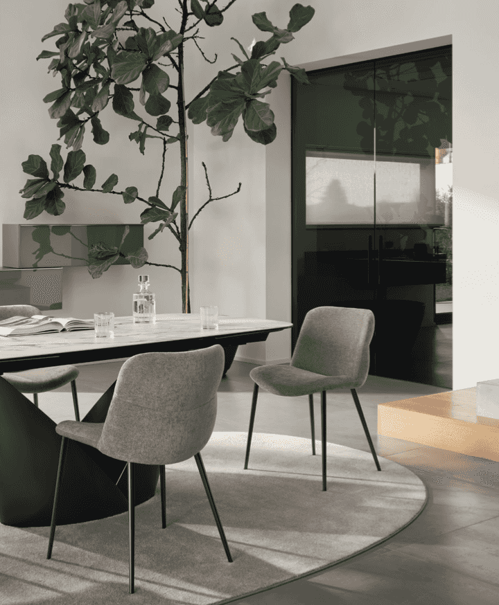 Gray upholstered CS2239 Onda Dining Chairs by Calligaris in a bright, modern dining room with a round table and natural lighting.
