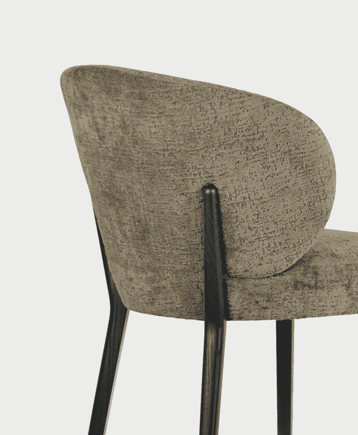 Close-up of the CS2243 Mara Dining Chair by Calligaris showcasing its curved backrest, plush fabric, and sleek wooden legs in a modern finish.