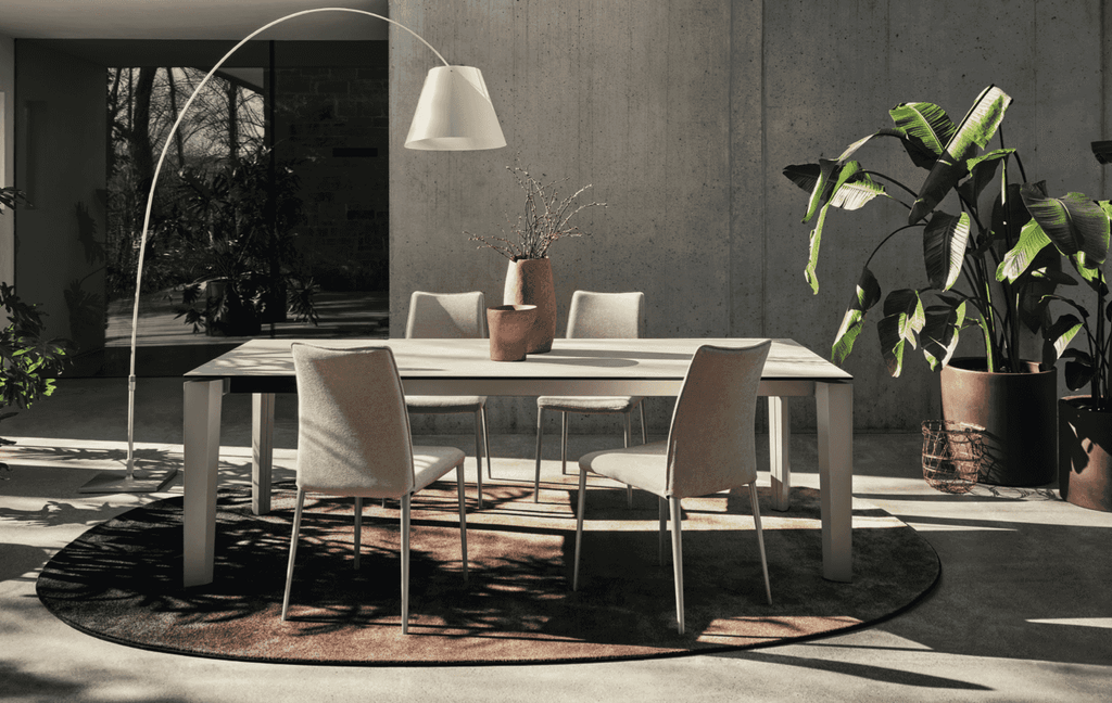 Round CS7192 Sky Rug by Calligaris in a neutral tone under a white dining table, enhancing a cozy and natural dining space.