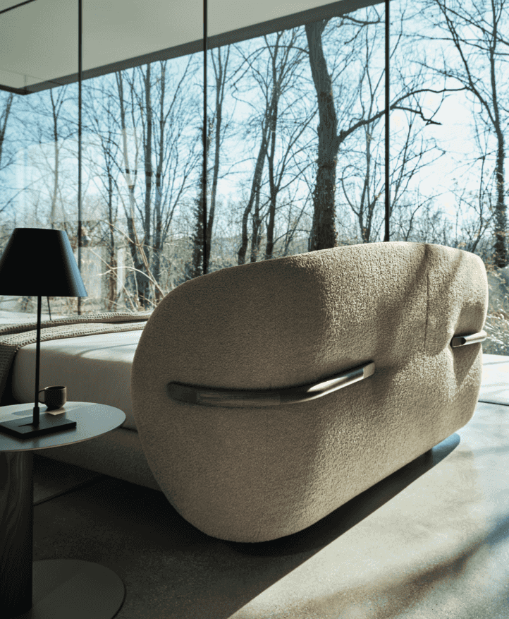 Rear view of the CS6218 Oleandro Bed by Calligaris Italy with boucle fabric and wooden accents, placed in a glass-walled bedroom with forest views.