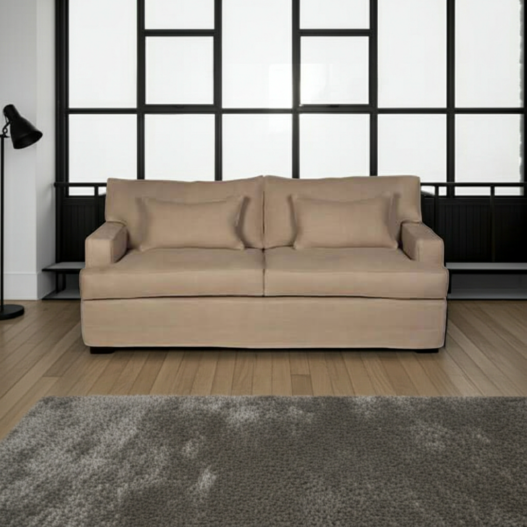 Beige sofa in a room with large windows and a gray rug.