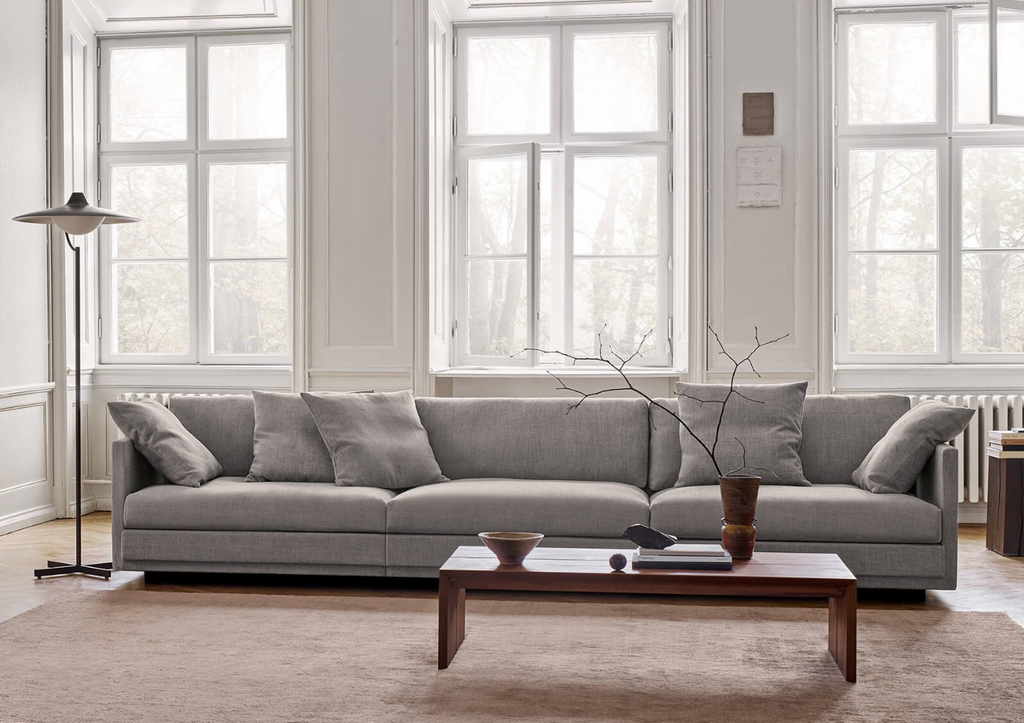 Grey Great Ash Sofa by Eilersen in a classic living room with tall windows and a wooden coffee table, blending comfort and elegance.