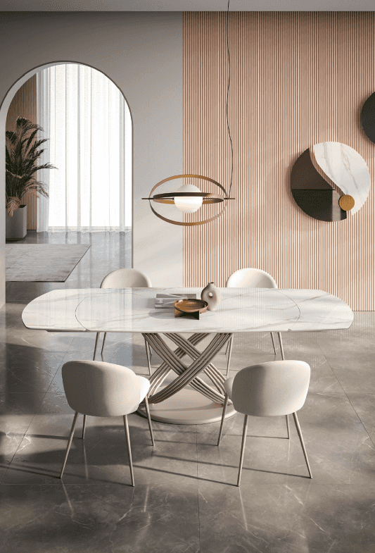 Elegant dining room with white marble table featuring a sculptural base, surrounded by cream upholstered chairs, modern lighting, and wall art