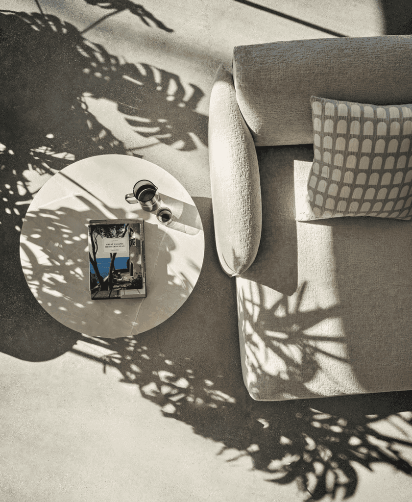 Top view of CS3469 Axis Low Sofa by Calligaris with patterned cushion and round coffee table, highlighting elegant textures and soft sunlight.