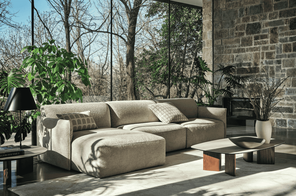 CS3469 Axis Low Sofa by Calligaris in a cozy, sunlit living space with stone walls and indoor plants, emphasizing comfort and Italian style.