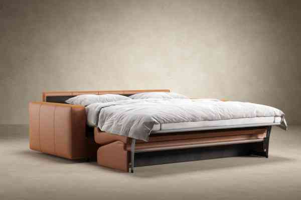 Innovation Living Carnell Leather Sleeper Sofa Bed fully extended into a queen size bed with plush bedding, perfect for guest accommodations.