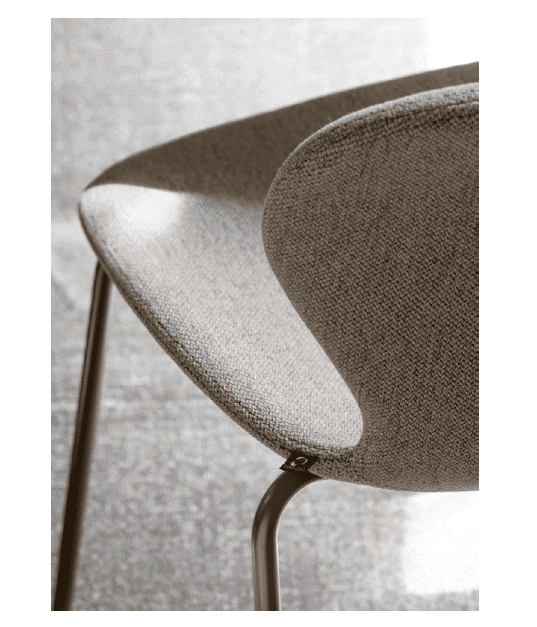 Beige fabric dining chair with rounded seat and backrest, featuring metal legs, shown on a textured gray carpet with neutral tones