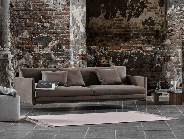 Ash Custom Fit Sofa by Eilersen in brown suede, styled in an industrial loft setting, available at Trade Source Furniture.