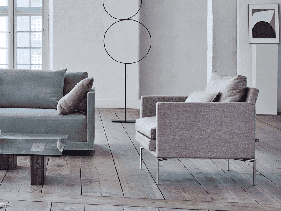 Quick Ship Ashton Chair by Eilersen in rose fabric beside matching sofa, featuring minimalist design and comfort-focused structure.