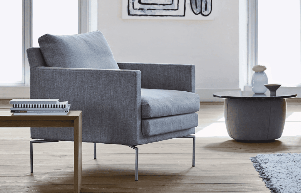 Quick Ship Ashton Chair by Eilersen in grey fabric with slim metal legs, shown in a modern living room at Trade Source Furniture.