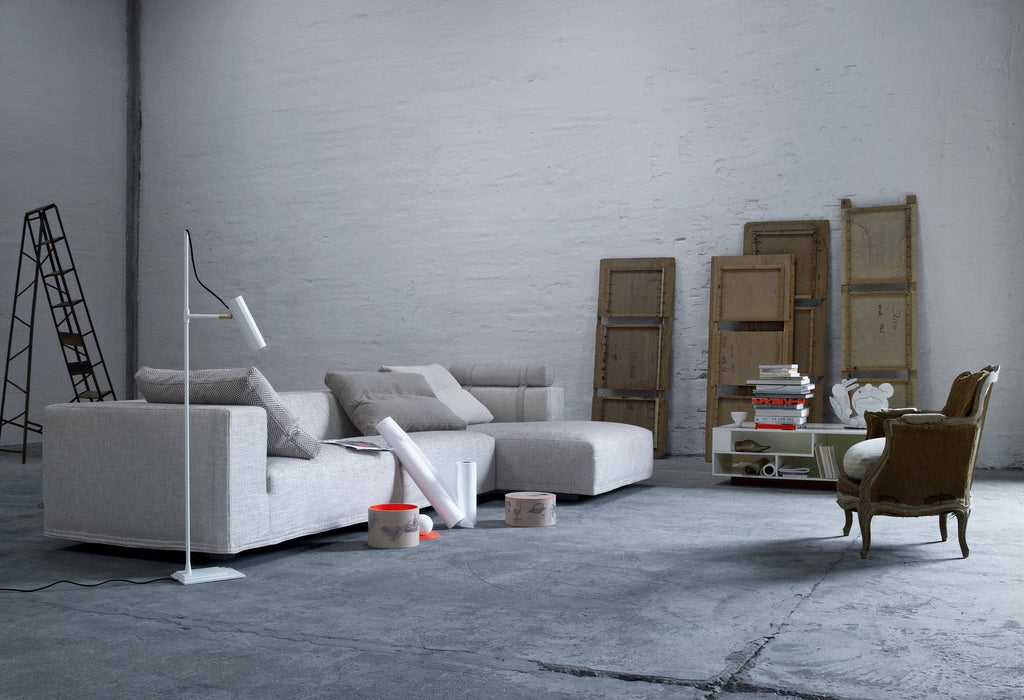 Quick Ship Baseline Sofa by Eilersen in a minimalist industrial space, styled with neutral tones and artistic decor elements.