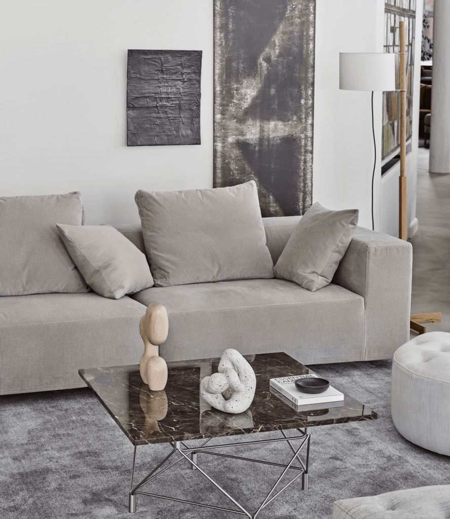 Eilersen Baseline Sofa with Chaise in neutral grey, featured in a contemporary interior with dark marble coffee table and abstract wall art.