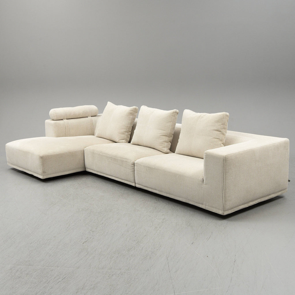 Eilersen Baseline Sofa with Chaise in cream corduroy fabric, featuring a head roll and three back cushions for added comfort.