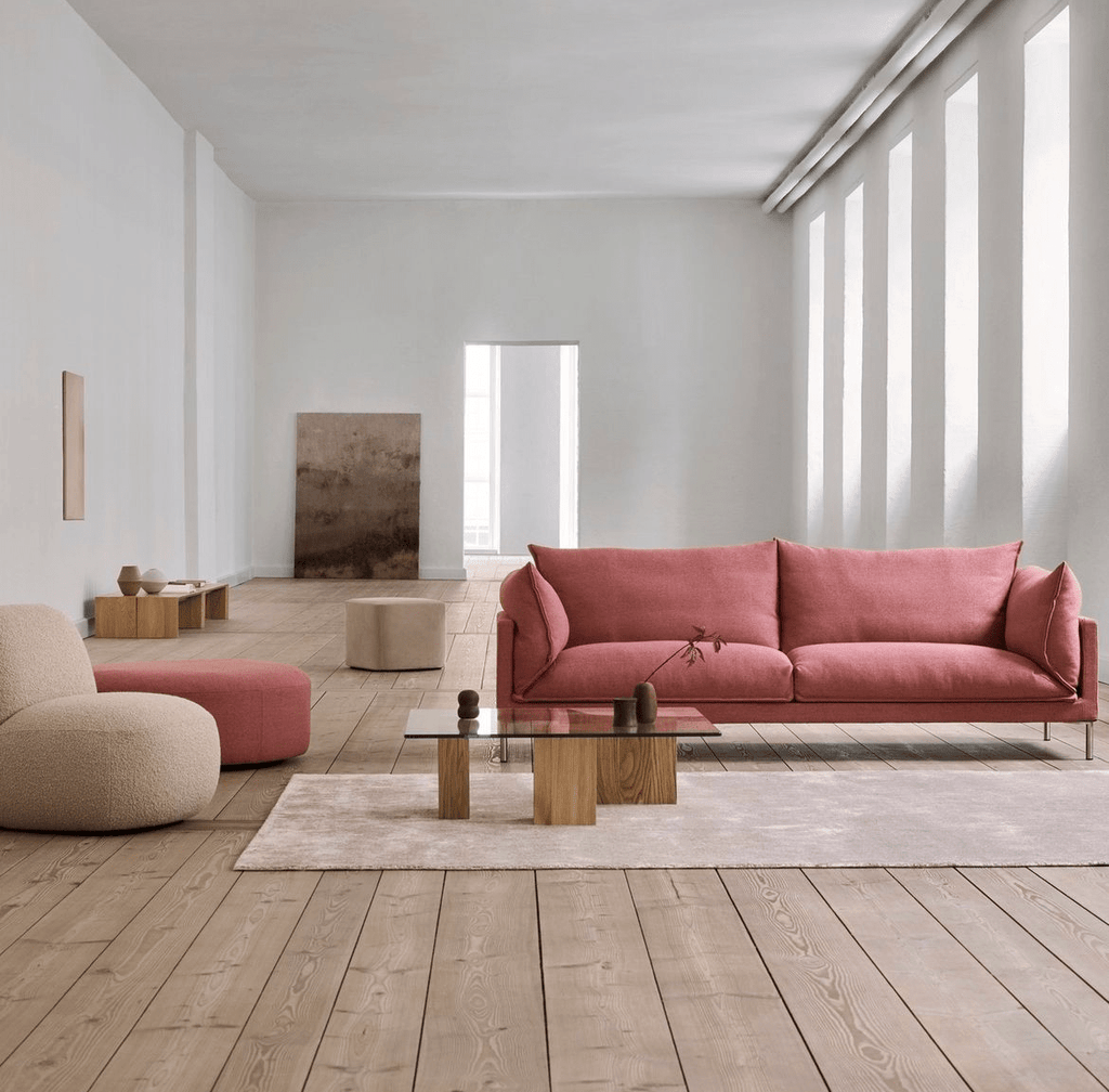 Butterfly Sofa by Eilersen in dusty rose fabric placed in a minimalist living room with wood flooring and neutral decor. Ideal for modern interiors.