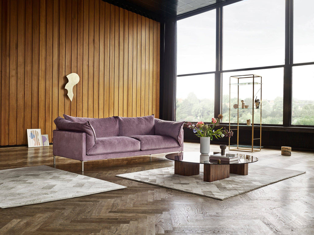 Butterfly Sofa by Eilersen in lavender fabric placed in a stylish room with wood paneling and modern decor, perfect for upscale interiors.