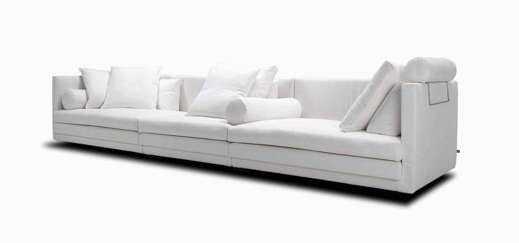 Side angle of Cocoon Sofa by Eilersen at Trade Source Furniture in white fabric, highlighting its plush cushions and structured modern frame.