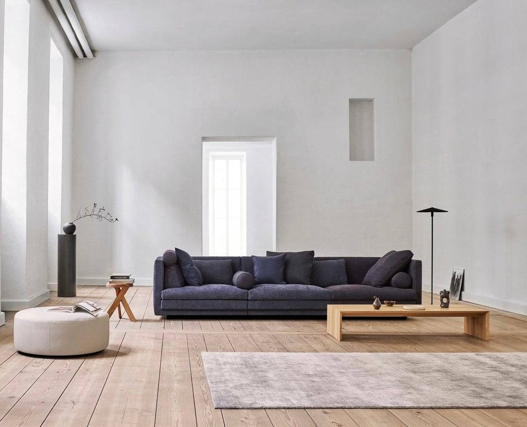 Wide view of Cocoon Sofa by Eilersen at Trade Source Furniture in blue fabric, styled with a low wood coffee table and neutral decor in a bright room.