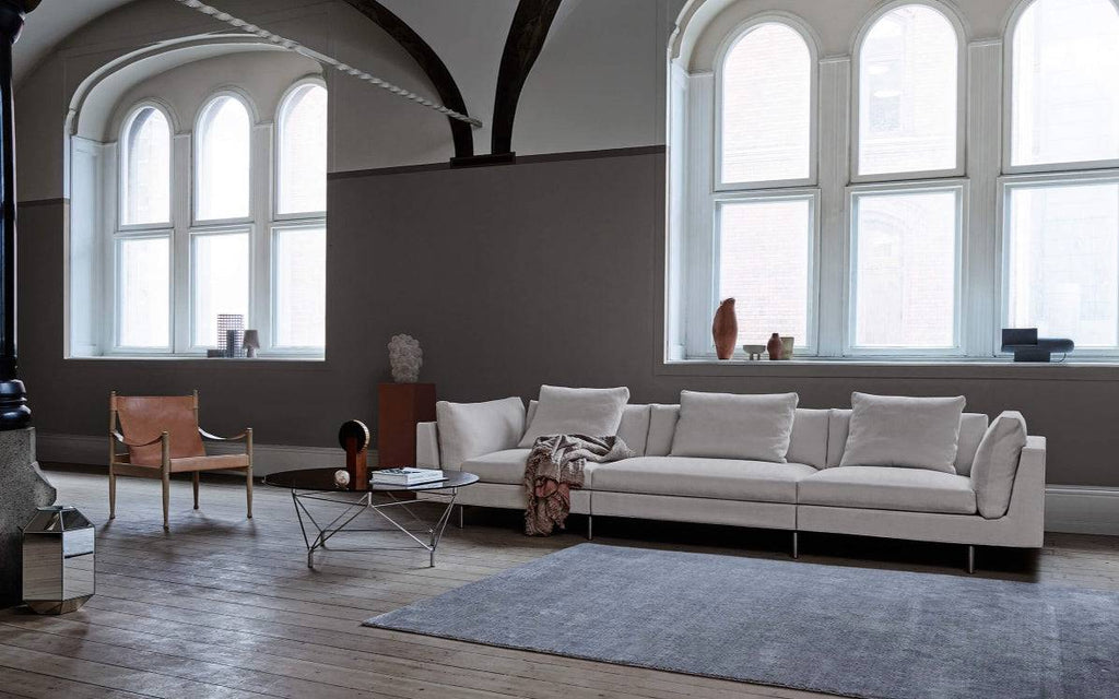 Float High Sectional Sofa by Eilersen in a modern living room with wood floors and arched windows, styled with neutral decor.