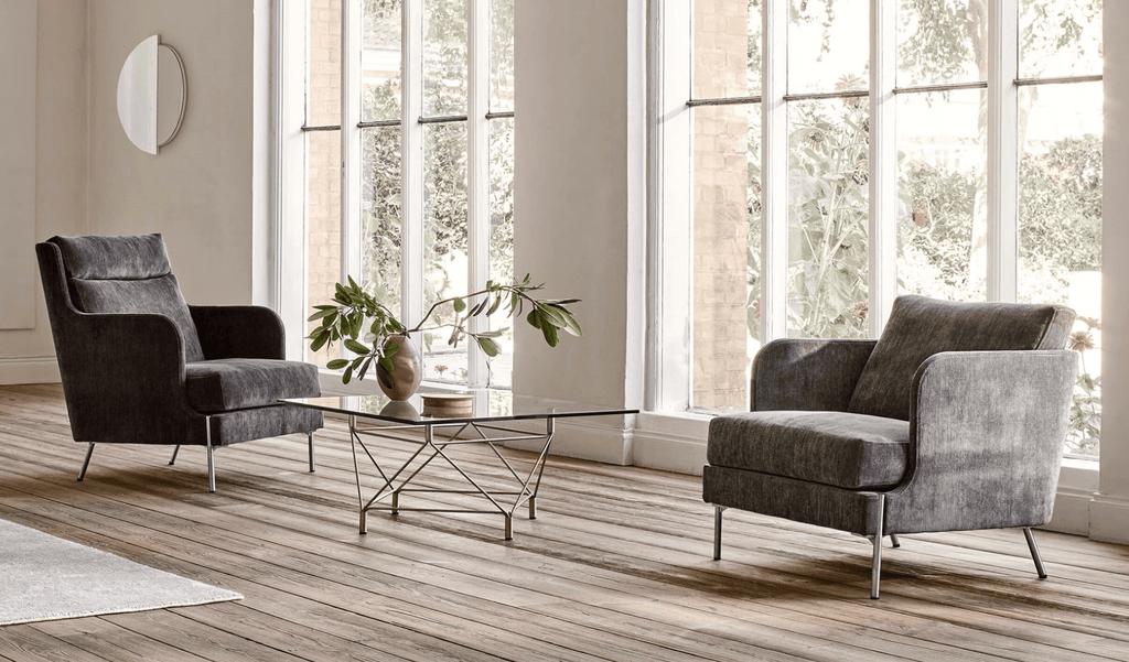 Funen Sofa and Chairs by Eilersen in a modern living room with large windows, showcasing sleek Scandinavian design and plush upholstery.