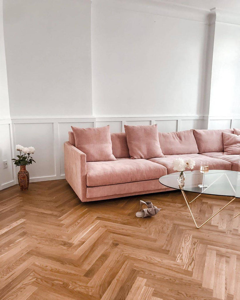 Pink Great Ash Sofa by Eilersen in a chic interior with herringbone wood flooring and glass coffee table, perfect for stylish homes.