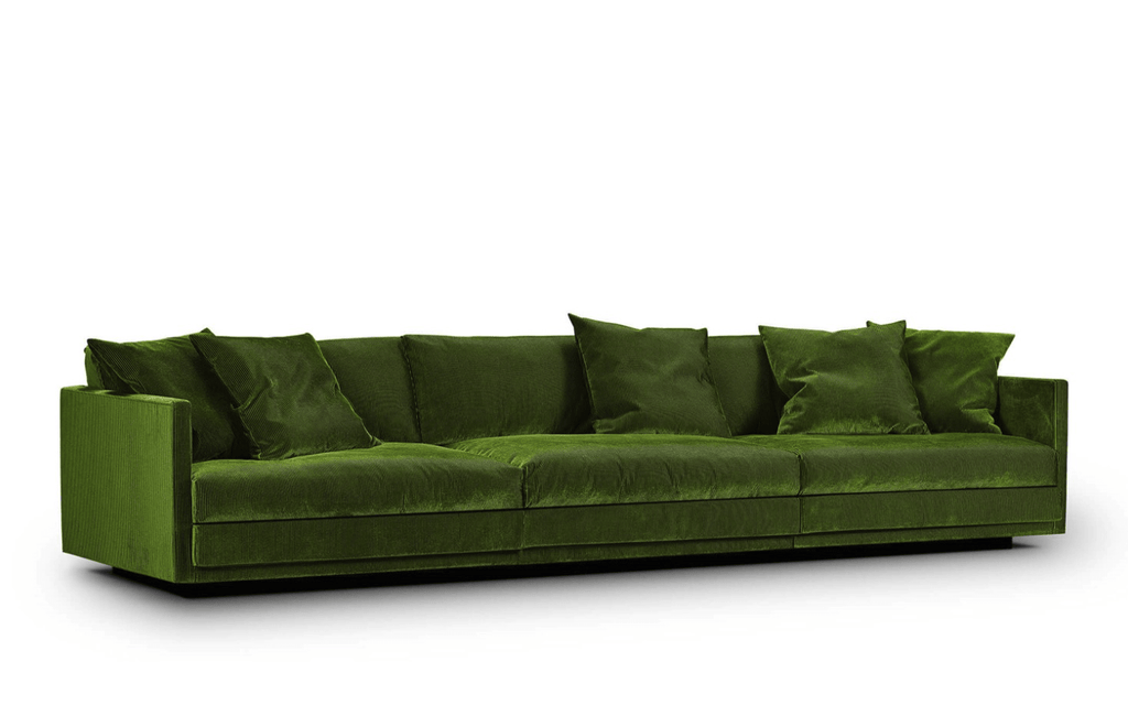 Side angle of the Great Ash Sofa by Eilersen in green velvet, highlighting its clean lines and plush back cushions.