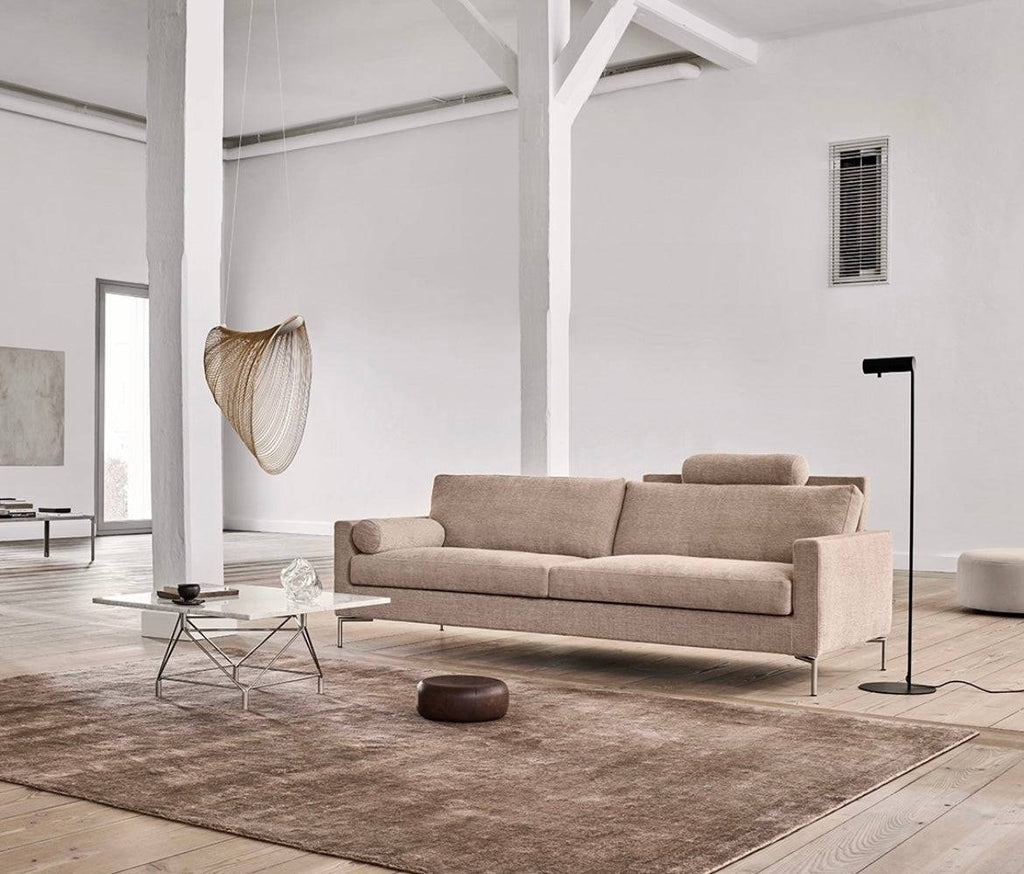 The Great Lift Sofa by Eilersen at Trade Source Furniture in a modern loft with neutral tones, showcasing its sleek design and adjustable headrest.