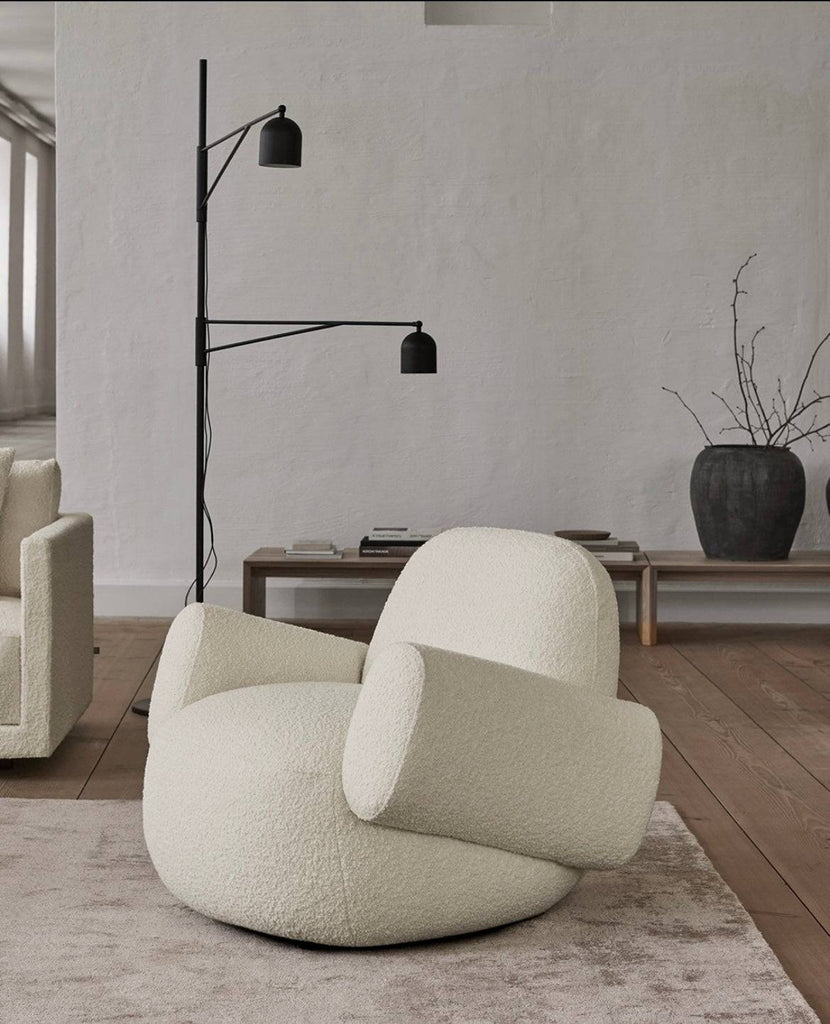 Havana Round Arm Chair by Eilersen in off-white boucle with round arms, styled in a minimalist room with wood floors and modern lighting.