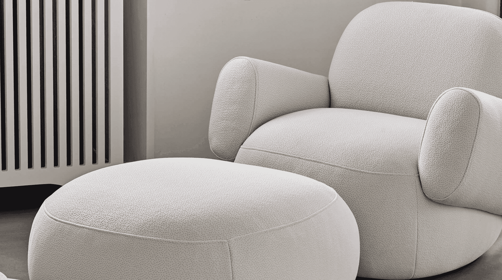Havana Round Arm Chair and matching ottoman by Eilersen in light boucle, styled in a cozy corner with neutral tones.