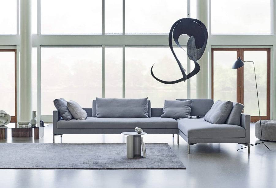 Eilersen Plano Sectional Sofa in a modern open space with floor-to-ceiling windows, styled with a grey area rug and sculptural decor.