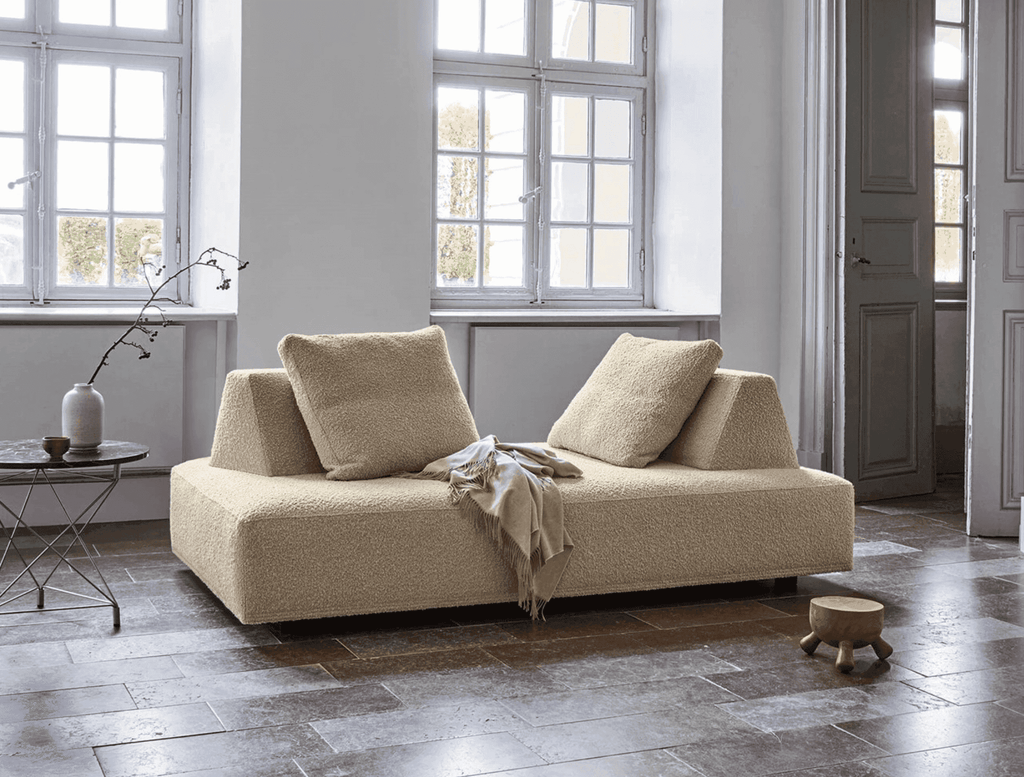Eilersen Playground Sofa in cream boucle with movable backrests, styled in a tiled-floor room with minimalist decor.