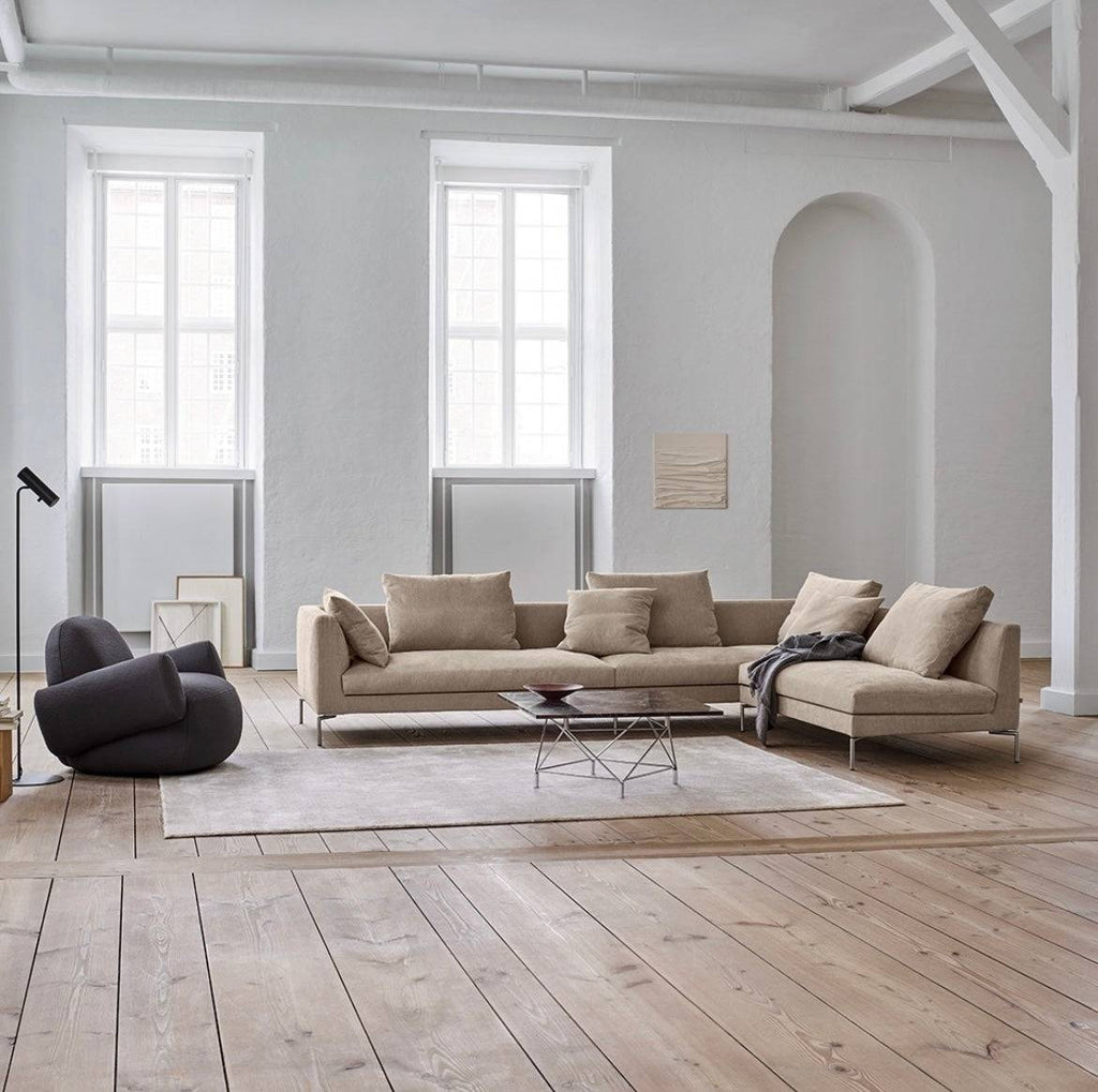 Quick Ship Ra Sectional by Eilersen in a spacious loft with natural light, showcasing its elegant design and plush cushions.