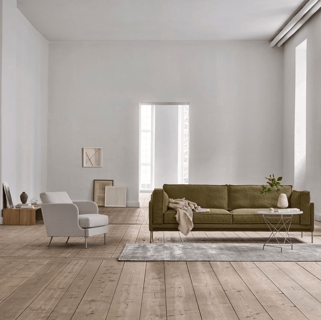 Slimline Sofa by Eilersen in green fabric styled in a minimalist living room with wood flooring and modern accent furniture.