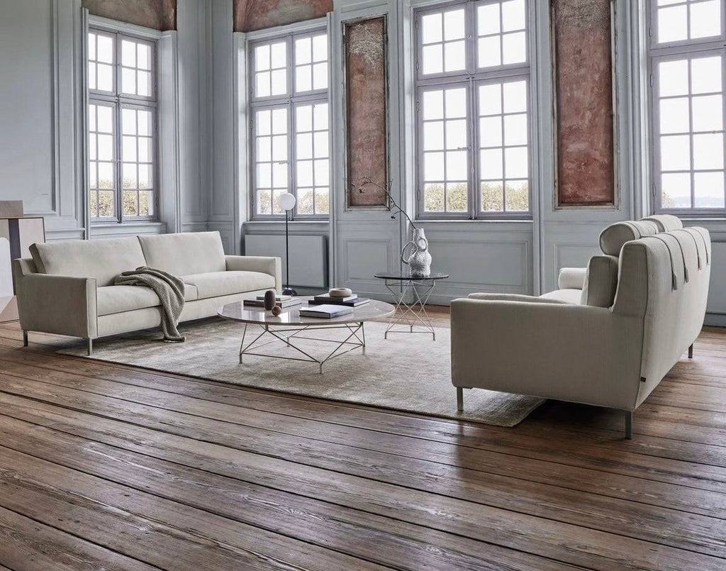 Elegant living room featuring two Streamline High Back Sofas by Eilersen in cream, arranged around a modern round coffee table on a neutral rug.