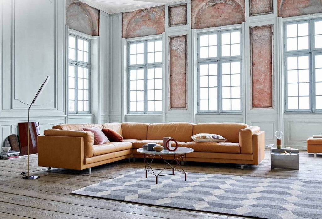 Eilersen Tub Sofa in caramel leather in a grand room with tall windows and geometric rug, available at Trade Source Furniture.