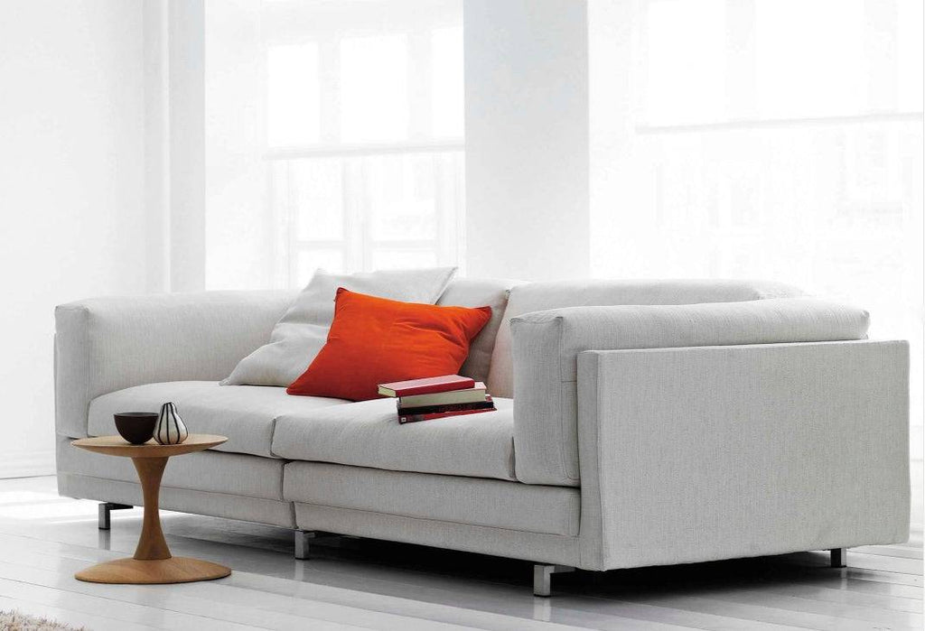 Light grey Tub Sofa by Eilersen with red accent pillows in a bright, modern room, showcasing its deep seating and clean lines.