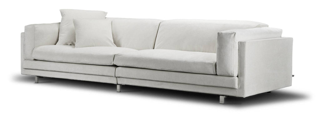 Angled view of the Eilersen Tub Sofa in white fabric, highlighting its plush cushions and sleek metal legs.