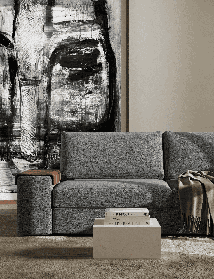 Black and white abstract artwork behind a gray Vilander sofa bed with wide arms in a contemporary living room