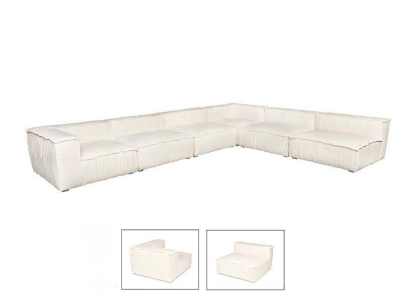 White modular sofa with clean lines and plush cushions, shown in a minimalistic room with light wood flooring and a geometric area rug
