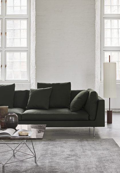 Close-up of Float High Sectional Sofa by Eilersen in dark green fabric, showcasing plush cushions and sleek metal legs.