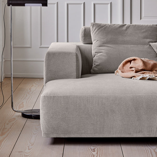 Close-up of the chaise section of the Eilersen Baseline Sofa in light grey corduroy, highlighting fabric texture and cushion detail.