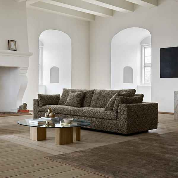 Amon Sofa by Eilersen placed in a spacious interior with neutral tones, showcasing its plush cushions and iconic design.