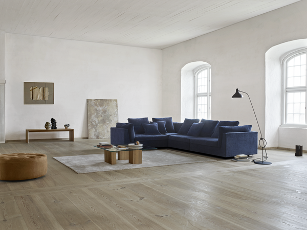 Spacious living room with navy Float Sofa sectional by Eilersen, styled with modern furnishings. Shop at Trade Source Furniture.