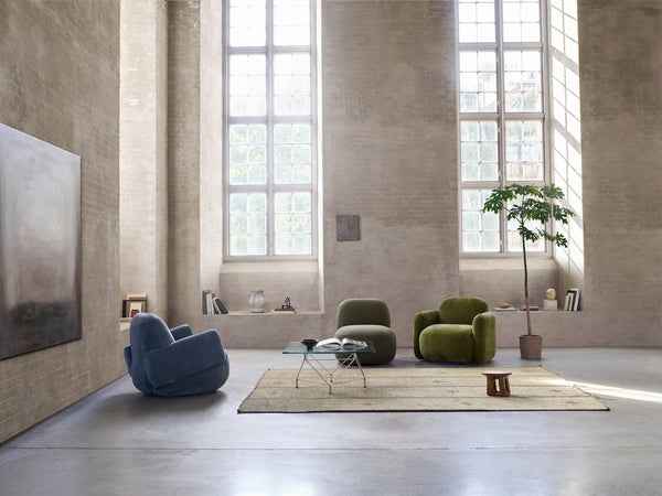 Close-up of Havana Lounge Chairs by Eilersen in green velvet, placed in a bright room with tall windows and a potted plant.